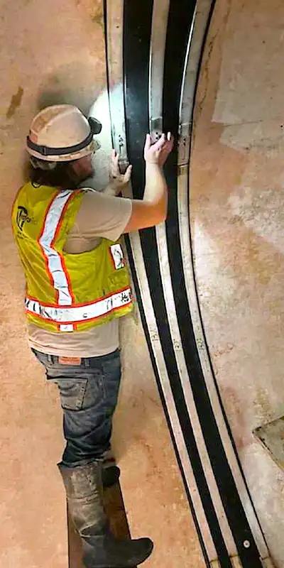 A technician installing HydraTite in a large diameter pipe