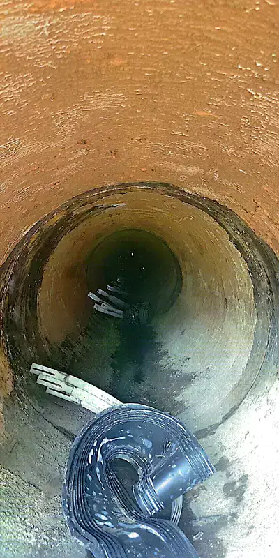 A long dark pipe where the tuberculation has been scrapped away from the interior wall near the pipe joint