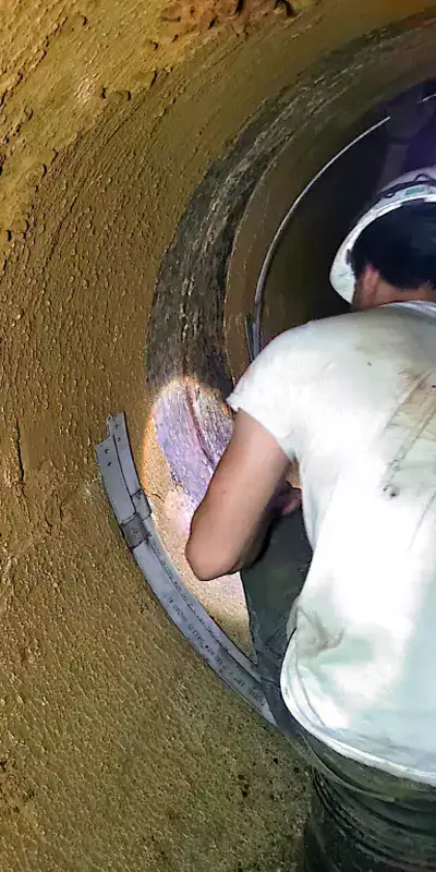 Technicians working inside a 48" pipeline to seal the joints with HydraTite