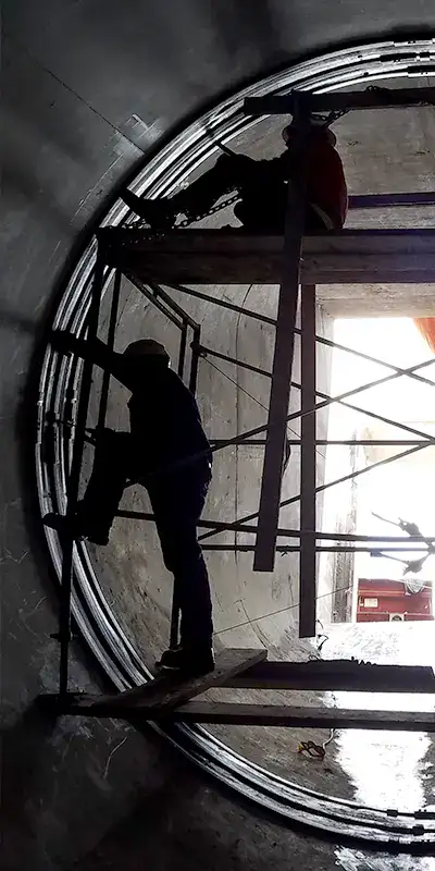 Technicians using scaffolding to install HydraTite over a joint in a large-diameter pipe