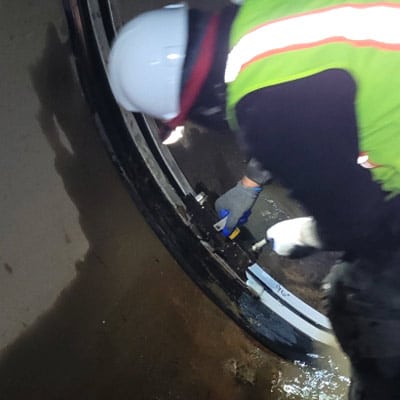 A technician installing HydraTite over a joint in a pipe