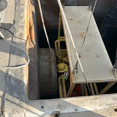 Technicians being lowered into a sanitary pipe