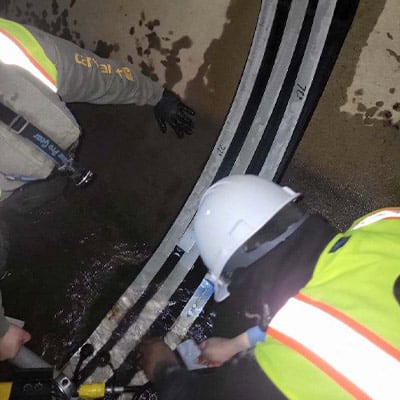 A technician installing HydraTite over a joint in a pipe