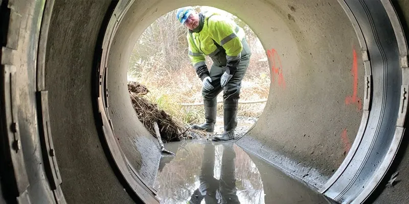 A technician is looking into a culvert to inspect a HydraTite seal project