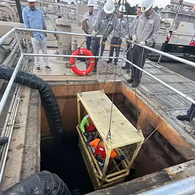 Technicians being lowered into a sanitary pipeline