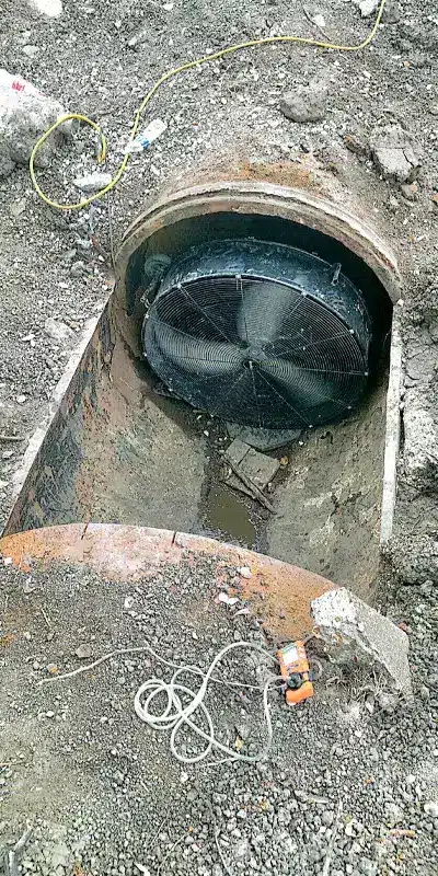 An open pipe with ventilation set up to keep the confined space workers safe