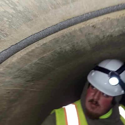 A technician looking at a joint that has been stuffed with foam filler