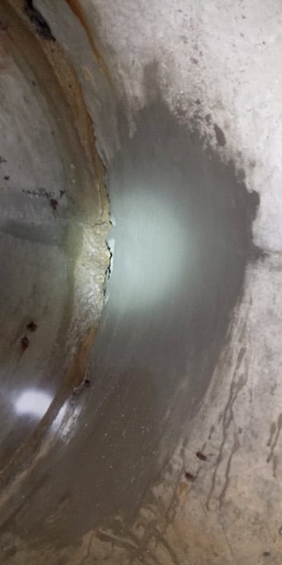 A patch of concrete inside a pipe near the joint