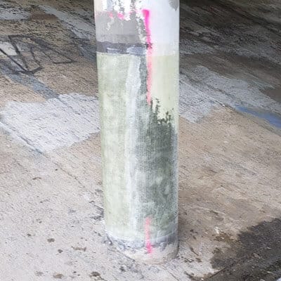 A column under a bridge being restored with a fiber composite wrap