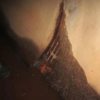A portion of concrete spalling and exposed rebar
