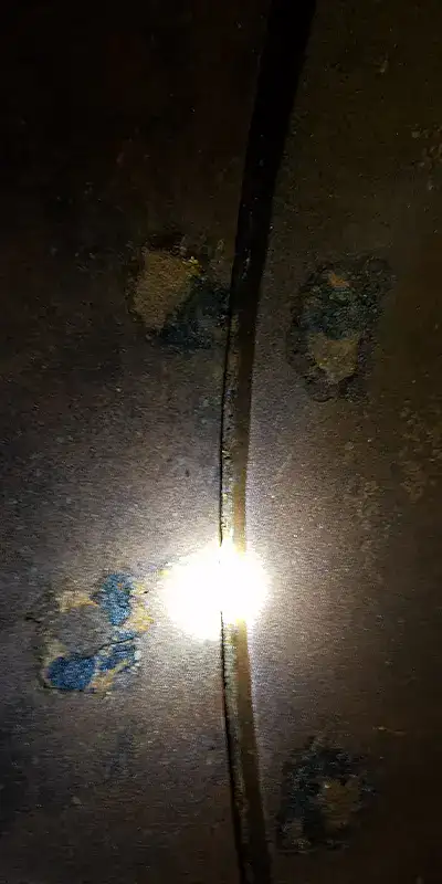 A light being shone on a separated joint in a drinking water pipe
