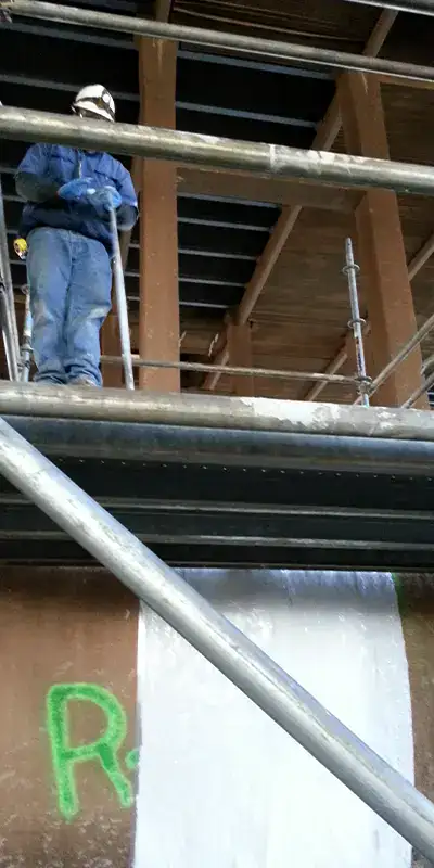 Two technicians working on the exterior of a large-diameter pipe