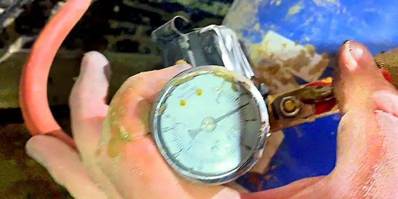 An air pump gauge being held by a technician