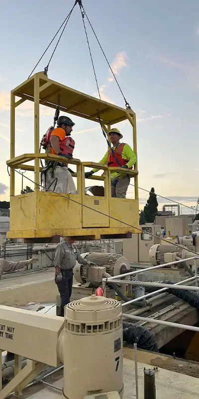Technicians being lowered into a pipe