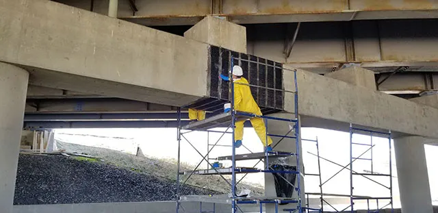 Carbon fiber fabric being applied to a bridge's supports