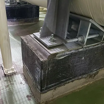 Piers under a tank wrapped in a carbon fiber reinforced composite