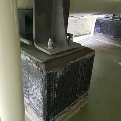 Piers under a tank wrapped in a carbon fiber reinforced composite