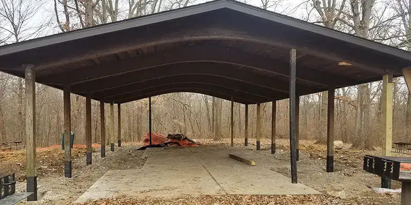 A row of wooden supports holding up a pavilion. The supports have been reinforced with HydraWrap