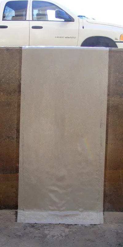 A crack running through a cooling tower basin's wall that has been restored with HydraWrap and top coated with a protective layer