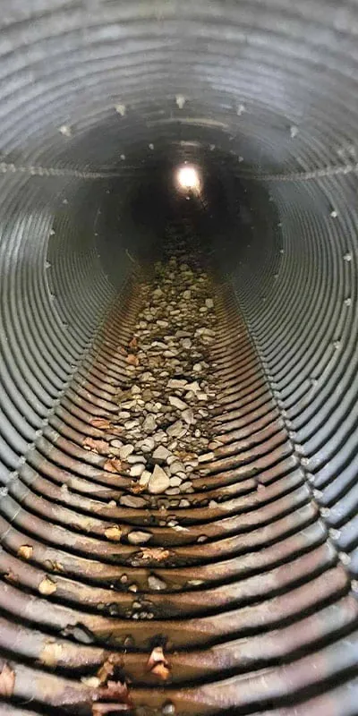 A rusty invert in a corrugate metal pipe