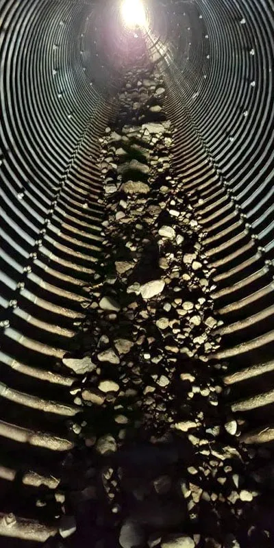 A rusty invert in a corrugate metal pipe