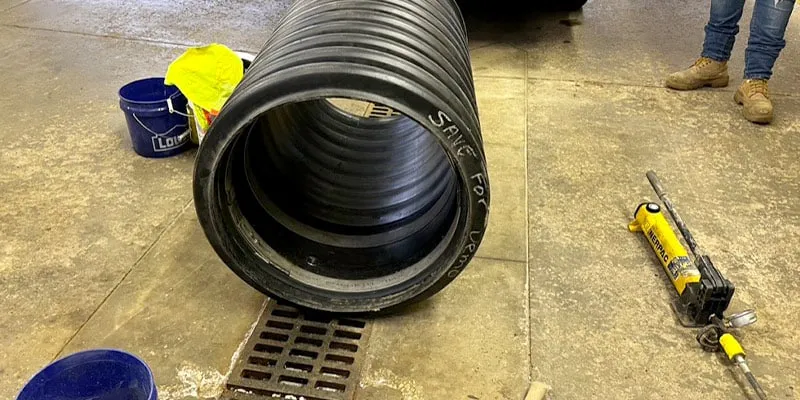 A portion of pipe sitting on a shop floor with a HydraTite seal installed inside of it as part of a demonstration to explain the installation process of HydraTite
