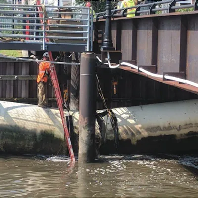 A technician standing atop a collapsed outfall sanitary pipe