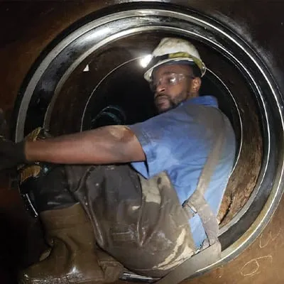 A technician working in a pipe to install HydraTite seal