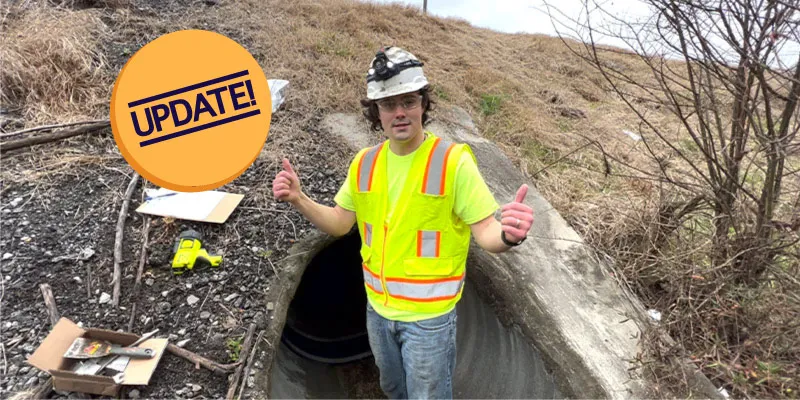 A technician using an expander to lock a retaining band in place to install HydraTite over a joint in a culvert