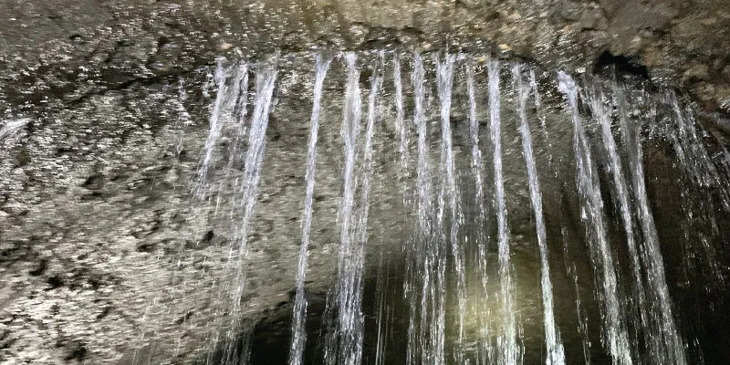 Water pouring into a pipe through the crown of a joint