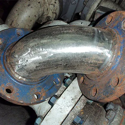 An elbow pipe that has been ground clean to remove corrosion and paint