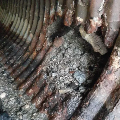 A portion of pipe wall that is missing due to corrosion in a corrugated metal pipe