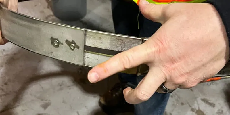 A technician expanding and contracting a retaining band to demonstrate its variable diameter
