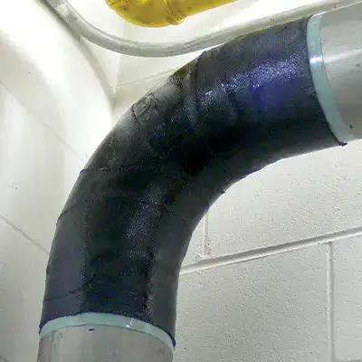 An elbow pipe wrapped with HydraWrap