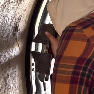 A technician expanding a retaining band, locking a HydraTite seal over a joint in a concrete pipe