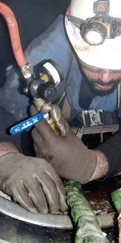 A technician working inside a pipe to install a HydraTite seal
