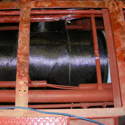 A large tee fitting in a water cooling system that has been restored with HydraWrap