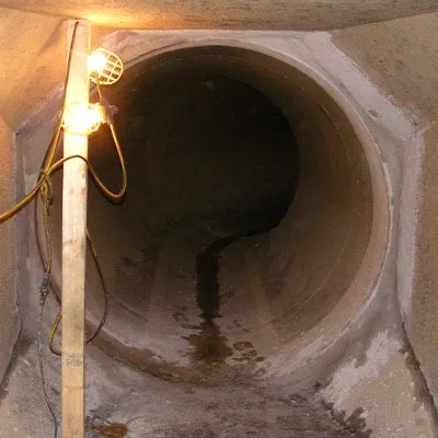 An irregular transition between 70 inch steel pipe and a rectangular concrete pipe. This joint has become compromised.