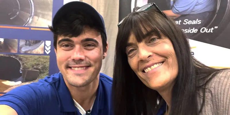 Jennifer and Caleb smiling at a tradeshow