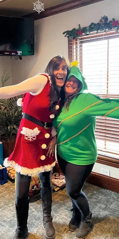 Two employees dressed in festive Christmas attire