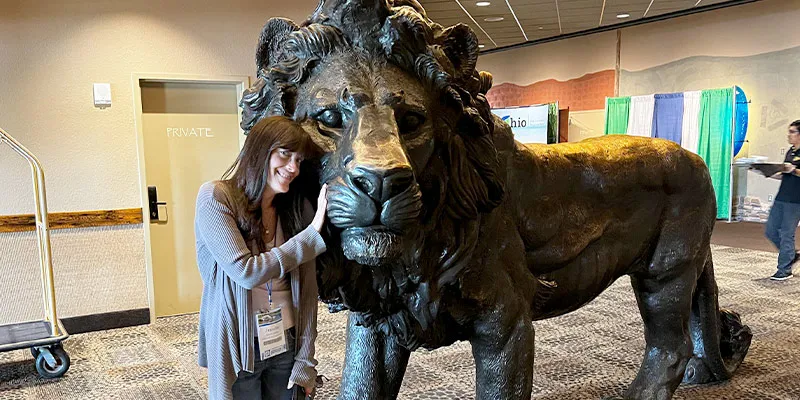 Jennifer standing next to a metal lion statue