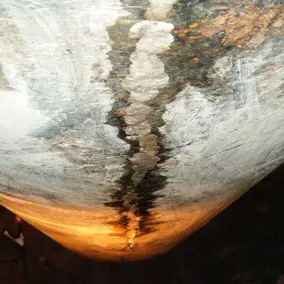An old cast iron supply line with visible corrosion and liquid collecting at the bottom of the pipe