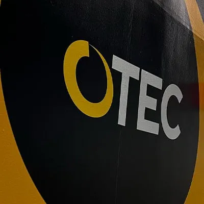 An OTEC sign on the wall of a tradeshow