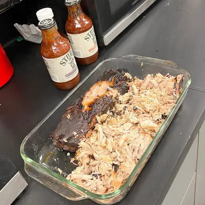 Pulled pork on a counter near bbq sauce