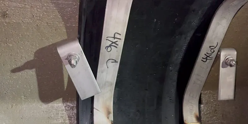 Hold-downs and retaining bands loosely positioned over the rubber of this HydraTite seal, in preparation for installation