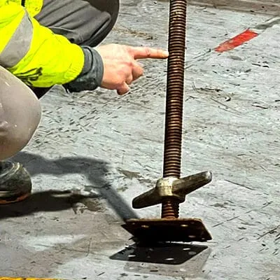 Adjusting the feet of scaffolding being set up