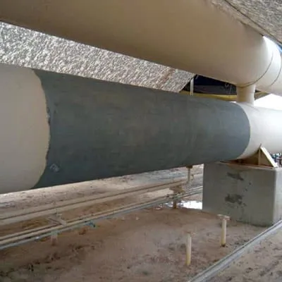 A portion of a 36-inch surge vessel that has had its surface ground clean in preparation for a HydraWrap application