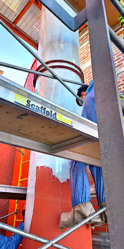 Two technician applying epoxy to the exterior of a vertical digester mixing pipe