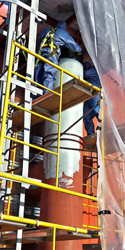 Two technician applying epoxy to the exterior of a vertical digester mixing pipe