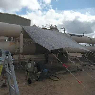 a tarp covering a portion of a 36-inch surge vessel at a natural gas facility. This cover allows technicians to work on the compromised portion of pipe